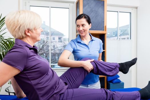 Physio doing rehab exercises with female patient