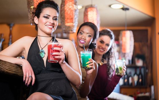 Girls enjoying nightlife in a club, drinking cocktails 