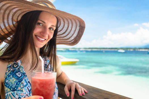 Woman in beachwear enjoying drink in beach cafe at sea