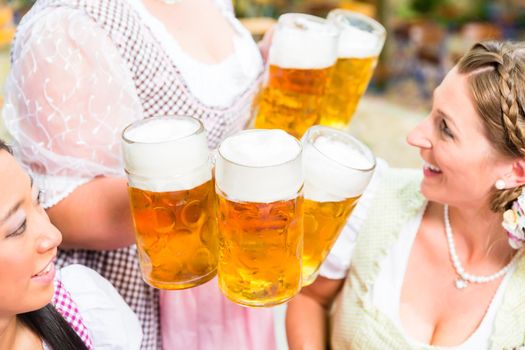 Waitress serving beer in five beer glasses