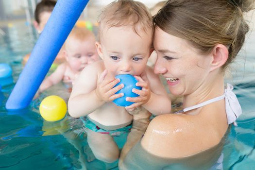 Mums and babies having fun at infant swimming course 