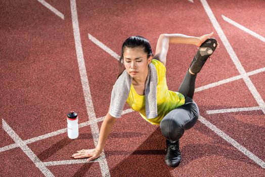 Woman sprinter doing warm up exercise before sprint