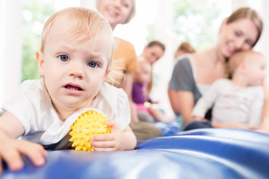 Babies and moms in postnatal mother and child course playing