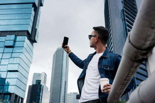 Young man taking selfie pictures in a modern business district of Jakarta