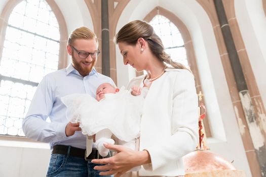 Parents with baby at christening in church