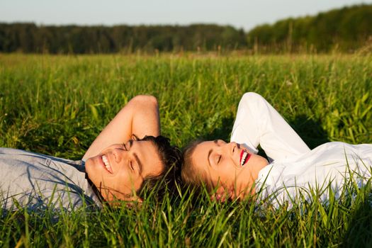 Couple sleeping on meadow in the sunshine