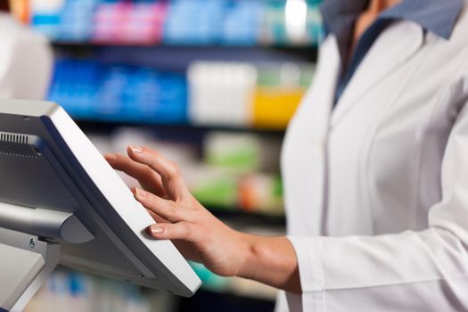 Female pharmacist at the cashier in pharmacy