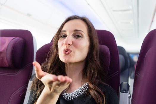 Happy woman tourist with pleasant anticipation on airplane