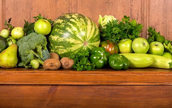 Useful green vegetables on a wooden background.