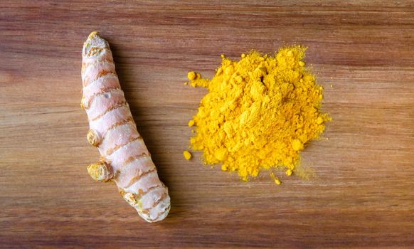 Turmeric root and spice powder on a cutting board