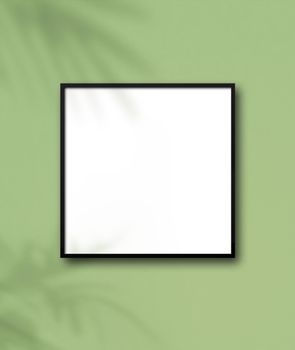 Black square picture frame hanging on a light green wall