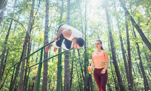 Sportive couple doing workout in outdoor gym