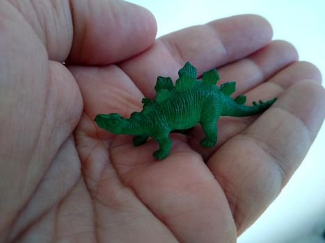 hand holding miniature dinosaur