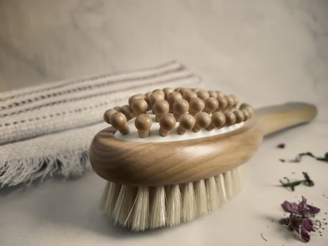 Wooden massage anti-cellulite brush on a linen towel close-up.