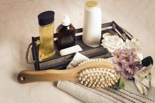 Massage brush made of natural wood and natural bristles and cosmetics.