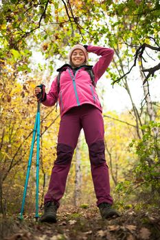 Hiking girl in a mountain. Low angle view in a forest. Healthy fitness lifestyle outdoors.