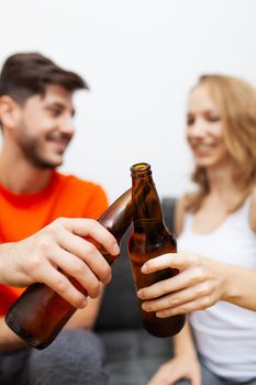 couple with beer bottles cheering