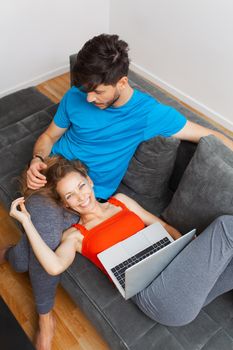 girl lying with laptop on boyfriend's lap