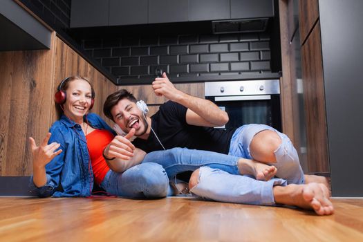 couple fooling aroung on the floor of a modern kitchen