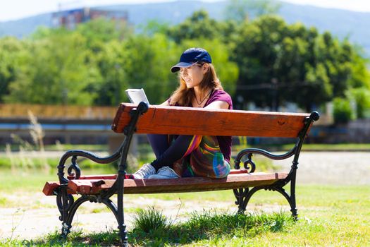 girl on a bench reading a book