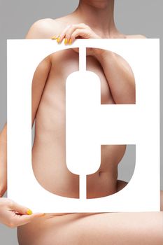 nude girl holding stencil letter c