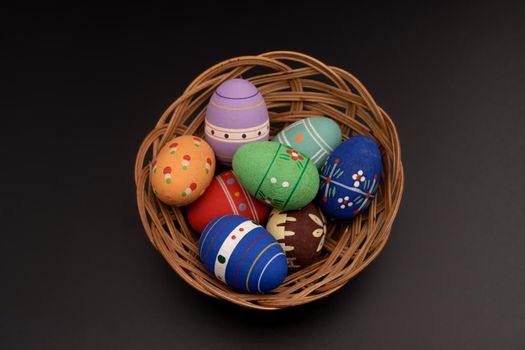 basket of twigs with Easter eggs on black