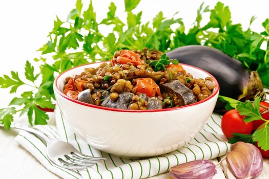 Lentils with eggplant in bowl on light board