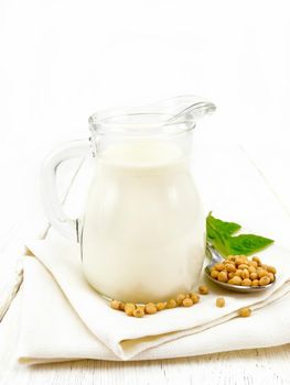 Milk soy in jug with leaf on light board
