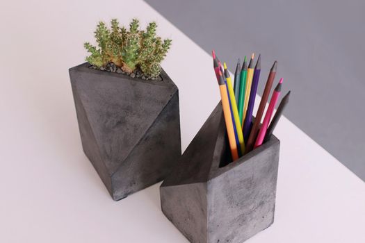 Two concrete organiser with cactus and pencils in