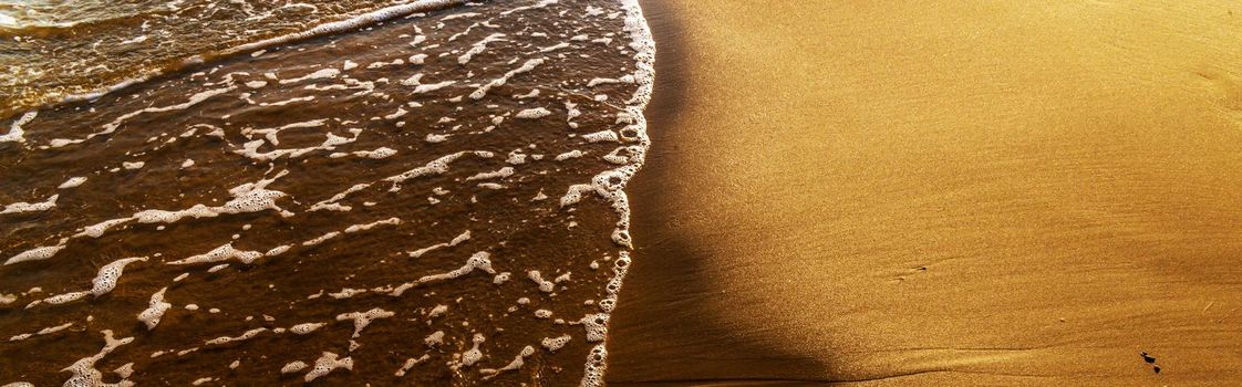 close up of the sea water affecting the sand on the beach, sea waves calmly flowing sand, relaxing view