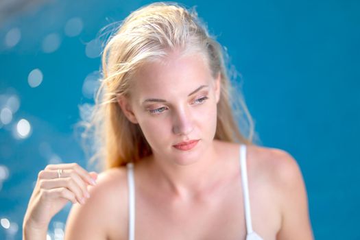 woman in white bikini tanning by the pool