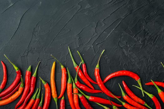 Ripe Cayenne pepper, on black stone background, top view flat lay, with copy space for text