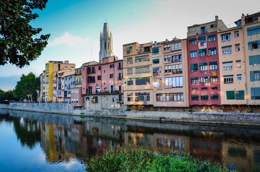 Colorful buildings reflected on river in Girona, Spain.