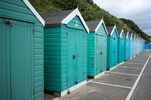 Colorful Beach huts, in green and blue colors, at the  boulevard in Bournemouth, Dorset, UK, England on a cloudy day in summer