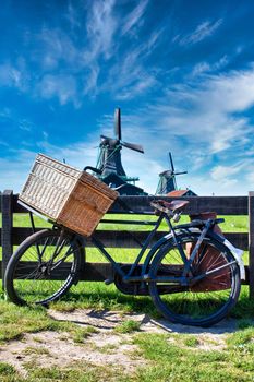 Bicycle with windmill and blue sky background. Scenic countryside landscape close to Amsterdam in the Netherlands. 
