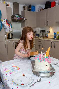 Baby Girl Blowing Candles Of A Birthday Cake