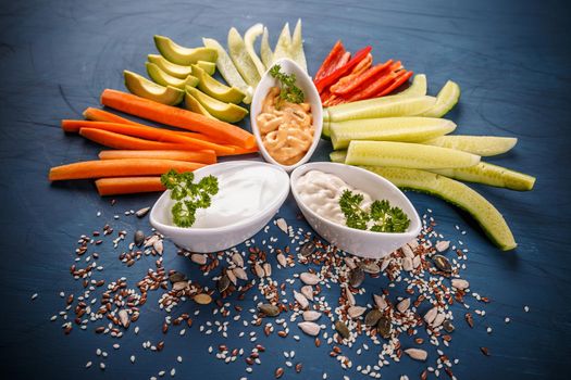 Healthy food concept: fresh vegetable snacks on blue background