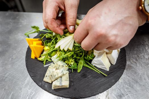 Chef garnishing cheese platter 