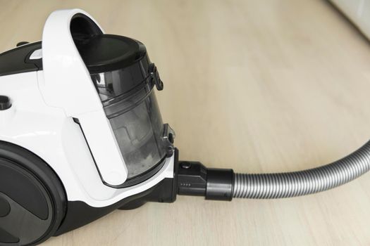 Bagless cyclone vacuum cleaner on a laminate. Electrical apparatus that by means of suction collects dust and small particles from floors and other surfaces.