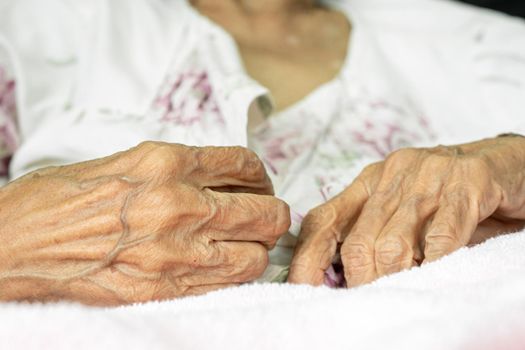 Elderly woman fasten buttons on dress , progressive brain disorder ,Close up hand