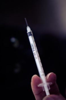 Insulin injecting syringe held by nurses hand