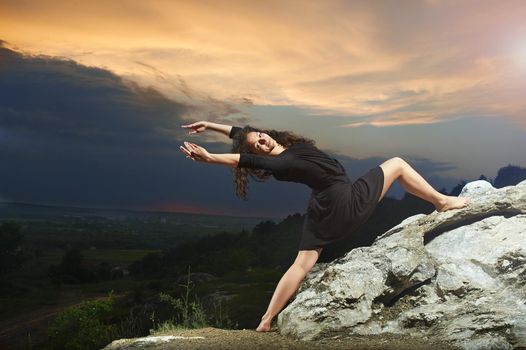pretty, young, curly dancing girl dancing in the mountains on the wonderful landscape at sunrise.4