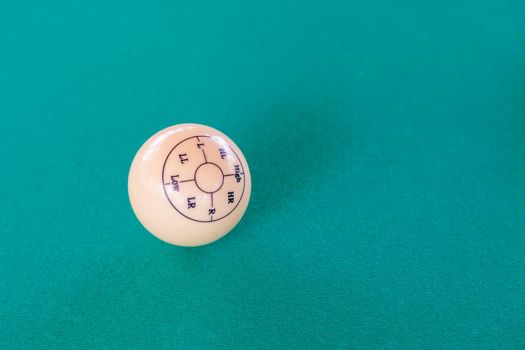 Ivory billiard ball. Impact direction marking. Close-up