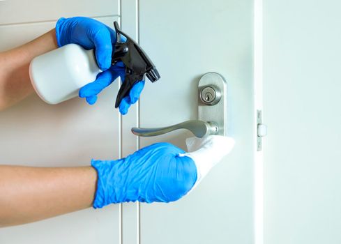 Cleaning door handles with an antiseptic during covid-19 viral epidemic