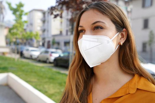 Close up of young woman looking to the side while wearing protective mask KN95 FFP2 outdoors