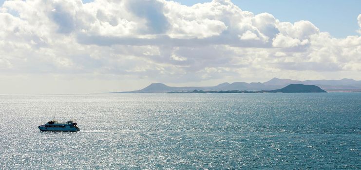 Ferry boat on Atlantic Ocean with Isla de Lobos and Fuerteventura islands on the background