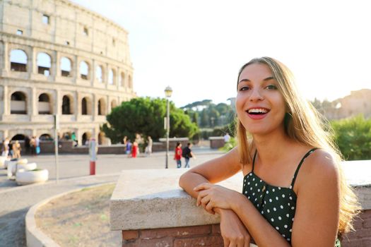 Roman Holiday. Smiling beautiful tourist girl in Rome, Italy. Attractive fashion woman with Colosseum on the background.