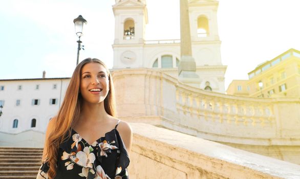 Portrait of fashion beautiful young woman goes down the Spanish Steps famous landmark of Rome. Summer holidays in Italy. Copy space area.