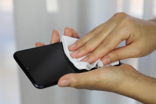 COVID-19 Pandemic Coronavirus Woman Cleaning with Wet Wipes Smart Phone Screen Disinfect Against Coronavirus Disease 2019 Outbreak Contamination Prevention