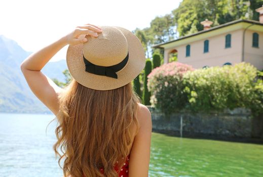 Lake Como Holidays. Back view of travel tourist girl relaxing enjoying view of Lake Como landscape from Bellagio town in Italy.